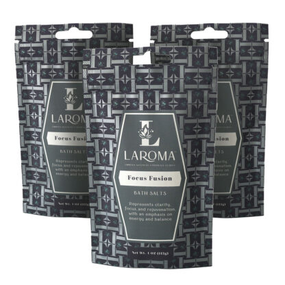 Three packets of Laroma Focus Fusion bath salts are displayed upright, featuring a geometric black and gray pattern with a central label describing the product’s focus on clarity, energy, and balance.